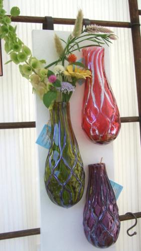 Wall Vase filled with flowers. Hangs on a nail. Available in many color options. Fill with fresh or dried flowers, root house plants or use as a scented oil diffuser. Approx 9-11" L x 4" W x 2.5" D